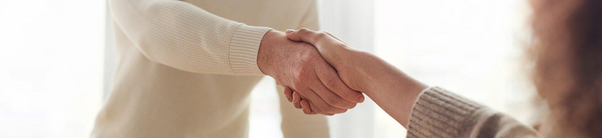 Two people shaking hands after making an agreement